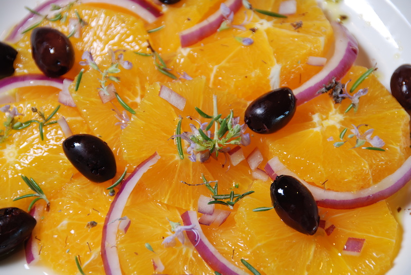 Slices of peeled oranges with kalamata olives, red onion and rosemary