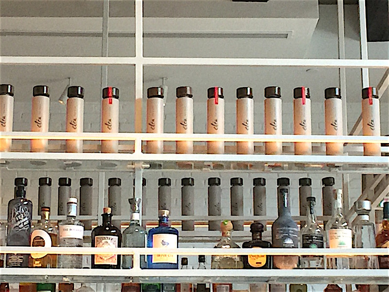 Bottles of Elea olive oil displayed on rack around bar