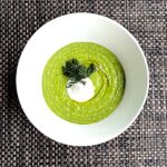 Avocado Pea Soup in a White Bowl with Garnish of Sour Cream and Dill Sprig