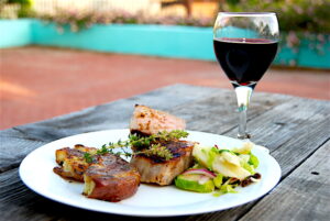 Brined Pan Seared Boneless Pork Chops with Smashed Potatoes, Brussel Sprout Salad and glass of red wine